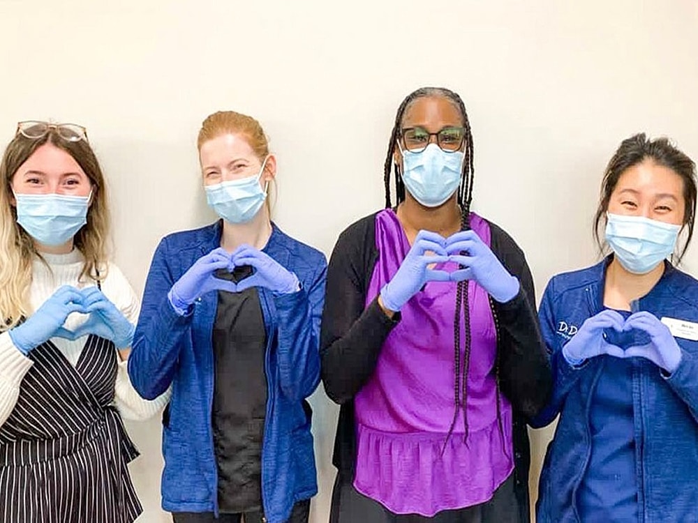 Healthcare workers making heart shapes with hands