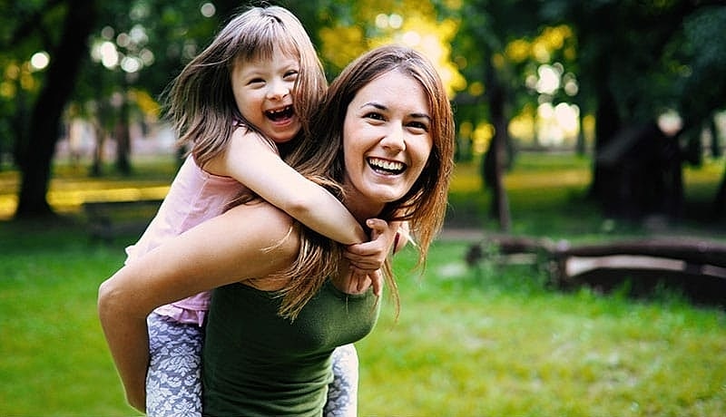 Mother and daughter smiling in a park.