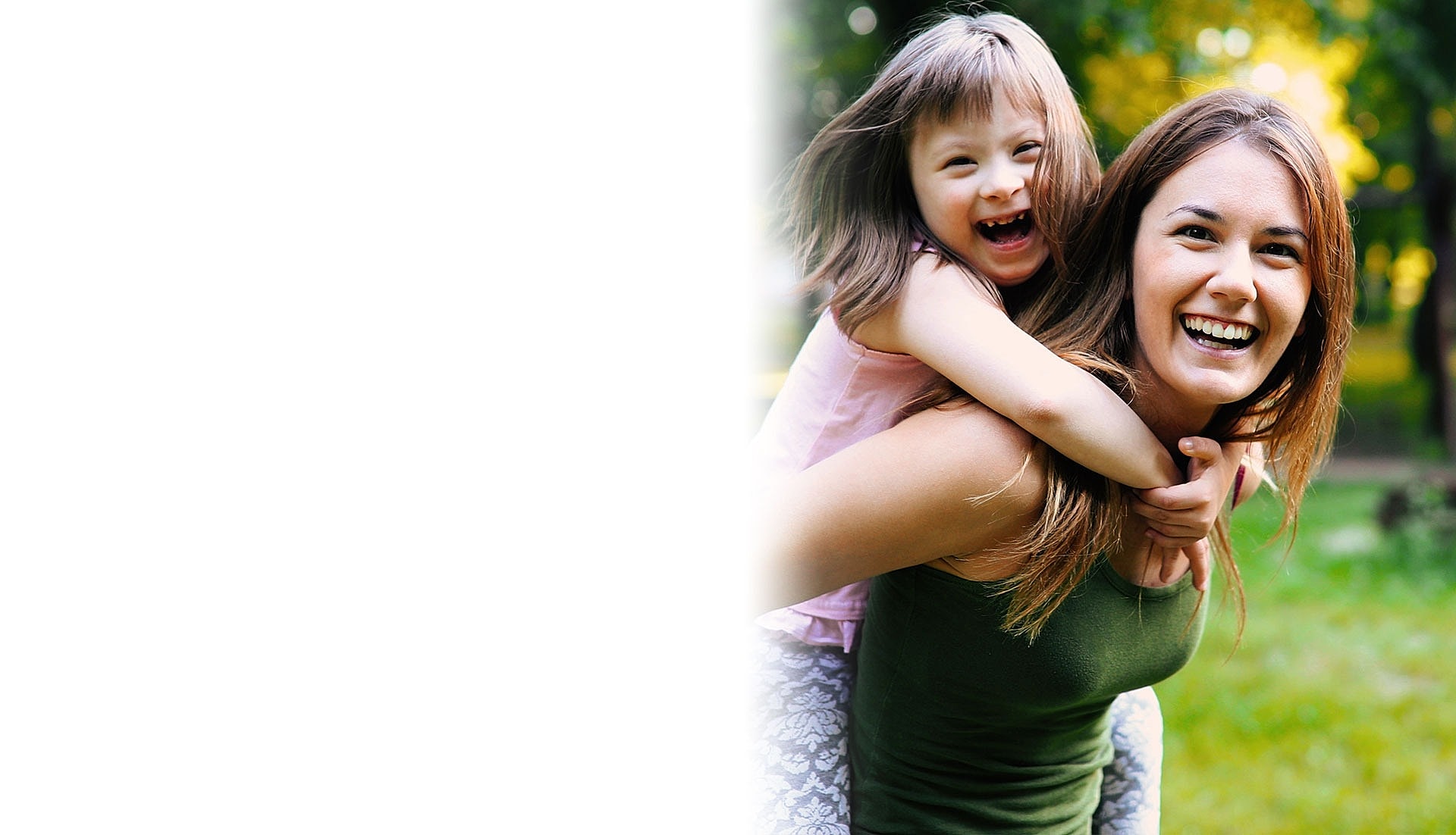Mother and child smiling in a sunny park.